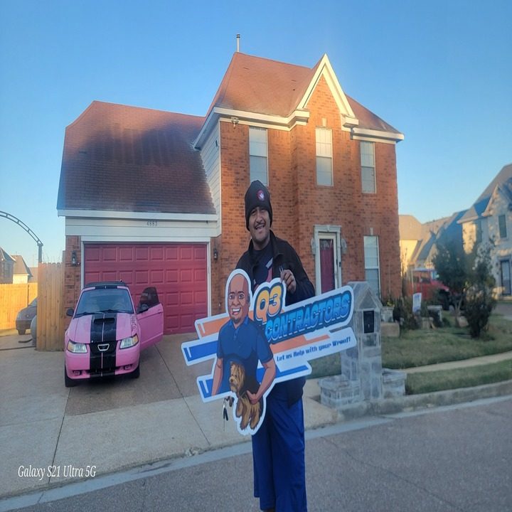 Homeowner in the Memphis area holding the contractor yard sign in front of their home after roof work